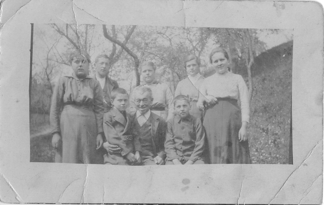 Zu sehen ist auf einem ausgeblichenen, alten Foto eine Familie